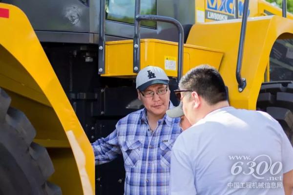 客戶仔細(xì)觀察裝載機(jī)，并不斷向工作人員詢問其性能參數(shù)
